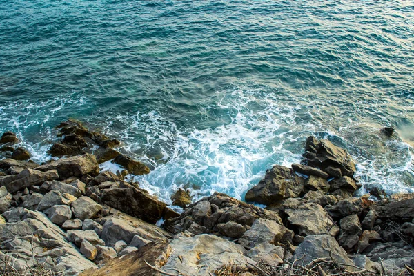 Výhled na moře. Vlny se rozvlní kolem pobřežních kamenů. Večerní osvětlení — Stock fotografie