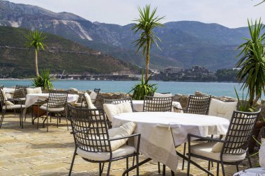 Denize yakın açık havada restoran. Masa ve sandalyeler üzerinde 