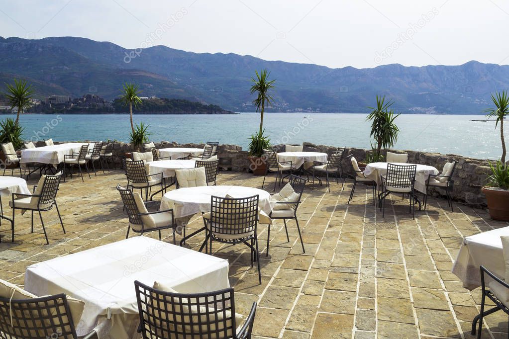 Restaurant in the open air near the sea. Tables and chairs on a 