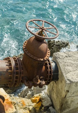 Deniz kıyısında büyük eski su kaynağı vanası.