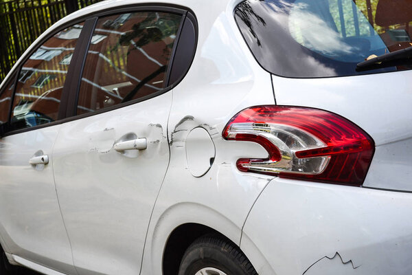 A car with a scratch on the body. Close-up