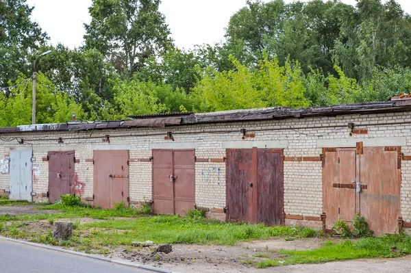 Řada cihel garáže s rezavé kovové brány. Rusko — Stock fotografie