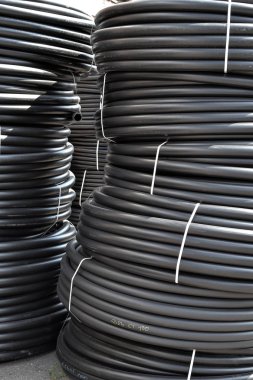 Açık havada saklanan sarmal siyah plastik borular