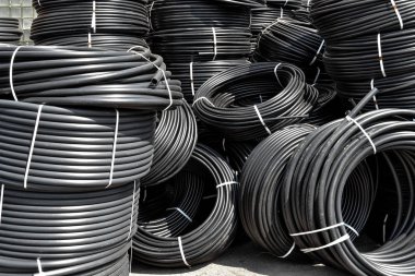 Spiral siyah plastik borular, açık havada saklanır. Arka plan