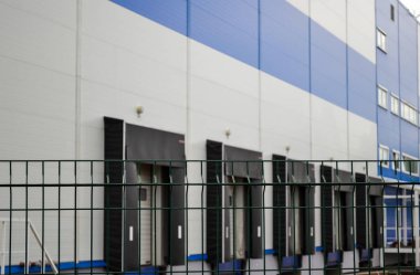 Kafesli çitin arka planında büyük dağıtım ambarı