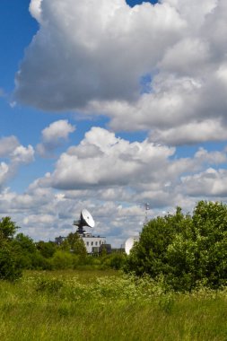 Mavi gökyüzüne karşı bir alanda uydu iletişim anteni. Uzay İletişim Merkezi