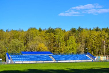 Orman bölgesinde bulunan bir stadyumda taraftarlar için tribün üzerinde Mavi koltuklar