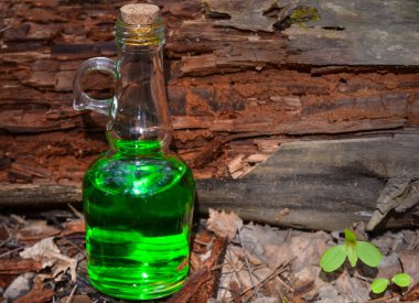 B karşı ormanda yeşil şeffaf sıvı ile Şişe