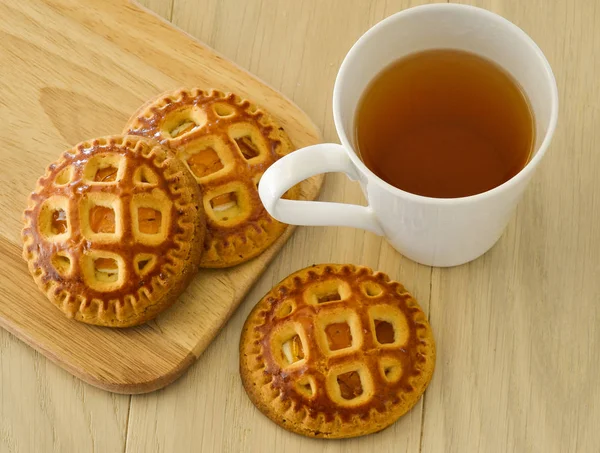 Ранковий чай з печивом. На легкому дерев'яному столі — стокове фото