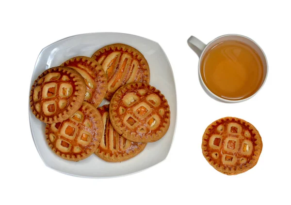 Biscuits aux abricots secs sur une assiette. Une tasse de thé. Vue d'en haut. Isolé sur fond blanc . — Photo