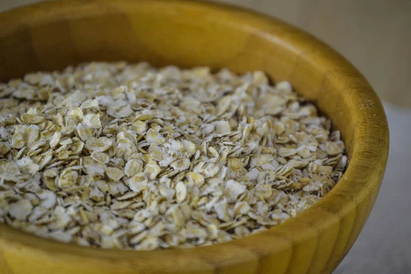 Oat flakes in a wooden plate close-up — Stock Photo, Image