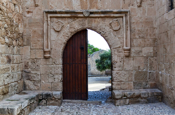 Old wooden open door on a stone wall: a way out of the castle