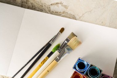 Boya fırçaları, çizim için beyaz bir kağıt üzerinde akrilik boya