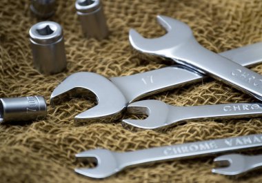 Kaba bir kumaşa yakın anahtarlar. Kahverengi arka plan. Yan görünüm.