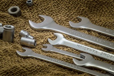 Kaba bir kumaşa yakın anahtarlar. Kahverengi arka plan. Yan görünüm.