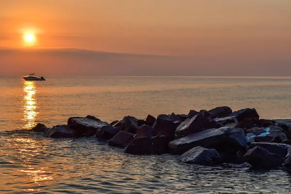 Amanhecer à beira-mar. Pedras, mar, barco. Grécia, Halkidiki, Kassandra — Fotografia de Stock