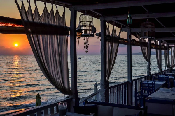 Caffè vicino al mare di tavole grezze con tende al tramonto o all'alba — Foto Stock