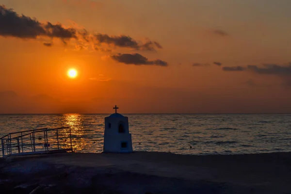 Agia marina monumento afogado pelo mar ao pôr do sol. Grécia . — Fotografia de Stock