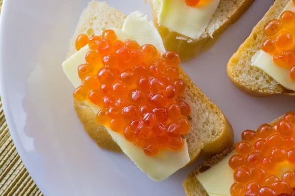 Caviar rojo sobre pan con mantequilla de cerca —  Fotos de Stock