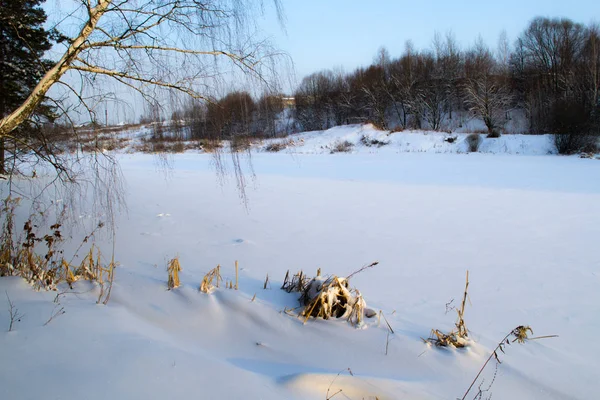 Der zugefrorene Fluss im Winter. Der Schnee bedeckt das Eis. Der Fluss ist komplett zugefroren — Stockfoto