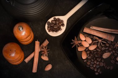 Yemek pişirmek için gıda maddeleri. Yıldız anason, tarçın çubukları, siyah bir arka plan üzerinde badem