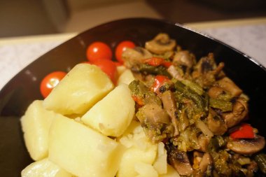 Mantar ve kiraz domates ile taze pişmiş haşlanmış patates. Close. Vejetaryen yemekleri. Diyet beslenmesi.