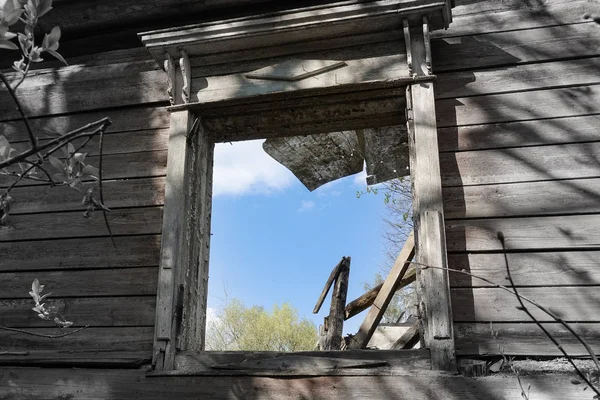 Fensteröffnung eines alten zerstörten Holzhauses. Russland. — Stockfoto