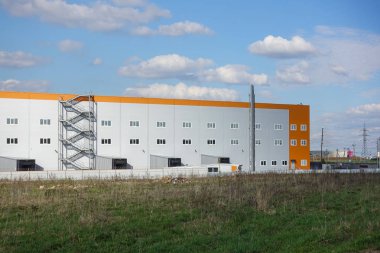 Endüstriyel bina, depo. Bulutlarla mavi gökyüzü.