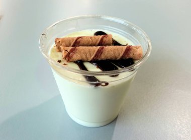 Vanilyalı puding tatlı bir fincan çikolata krema ile kaplı.