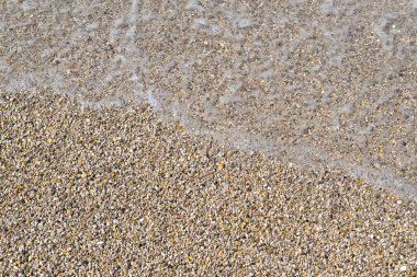 Bir çakıl plaj üst görünümünde deniz köpüklü dalga