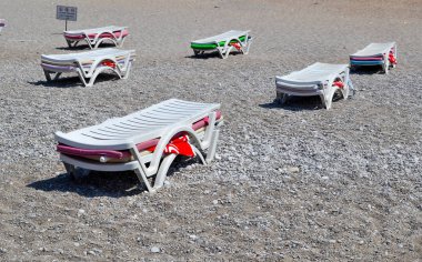 Şezlonglar, bir yığın halinde toplanır. Sahil sezonunun sonu. Plaj kapatma