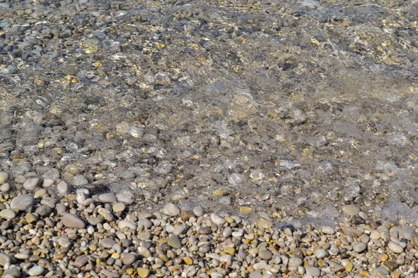Piedras marinas en el agua de mar. guijarros bajo el agua. La vista desde arriba. Fondo náutico. Agua de mar limpia. Mar transparente. — Foto de Stock