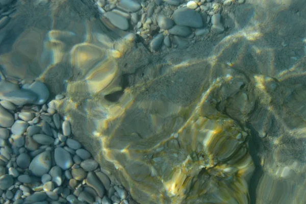 Vista superior de aguas transparentes de río o arroyo con piedras de guijarro. Fondo de naturaleza abstracta — Foto de Stock