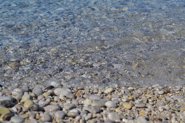 Sea stones in the sea water. Pebbles under water. The view from the top. Nautical background. Clean sea water. Transparent sea. — Stock Photo, Image