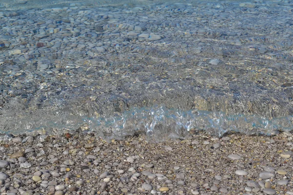 Μικρά βότσαλα και υγρή άμμο στη θάλασσα παραλία? γραμμή νερού. Ηρεμία διαφανές νερό. — Φωτογραφία Αρχείου