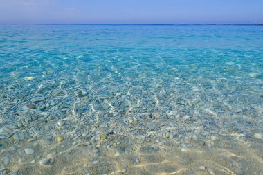 Deniz manzarası. Işık taşmaları ile sakin masmavi su.