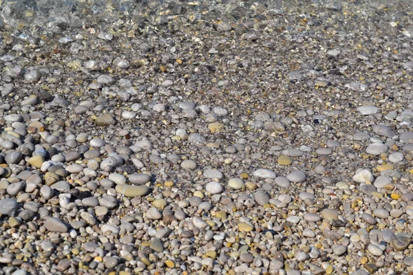 Onda marina si sposta su una spiaggia di ciottoli. Giornata estiva di sole. Vista dall'alto — Foto Stock