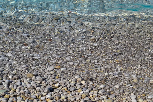 Valul mării se mută pe o plajă cu pietricele. Ziua însorită de vară. Vedere de sus — Fotografie, imagine de stoc