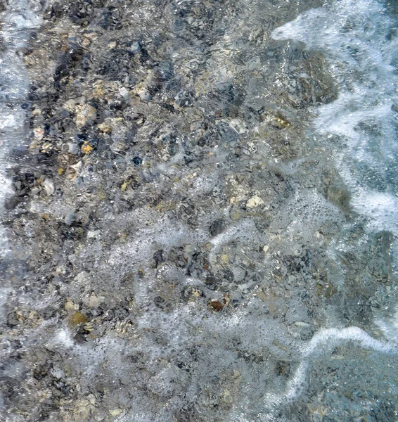 Piedras marinas en el agua de mar. guijarros bajo el agua. La vista desde arriba. Fondo náutico. Agua de mar limpia. Mar transparente. — Foto de Stock