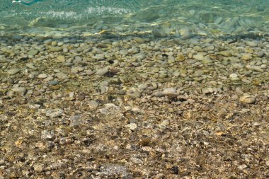 Deniz suyunda deniz taşları. Suyun altındaki çakıl taşları. Yukarıdan manzara. Denizcilik geçmişi. Temiz deniz suyu. Şeffaf deniz.