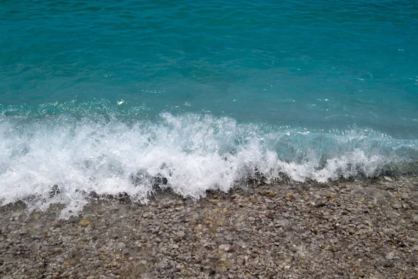 Un gros plan de galets et de mousse de mer. Vagues éclaboussures et éclaboussures contre le rivage, pousse macro — Photo