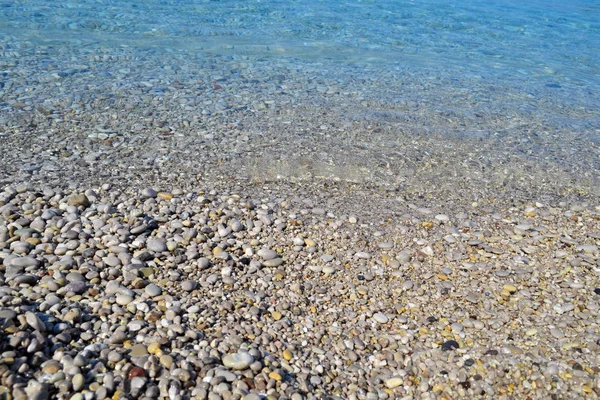 Textura de fundo abstrata praia com seixos, areias e água do mar em peru bodrum — Fotografia de Stock