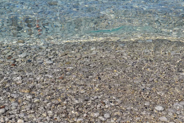 Αφηρημένη υφή στο φόντο της παραλίας με βότσαλα, άμμο και θαλασσινό νερό στην γαλοπούλα του Μπόντρουμ — Φωτογραφία Αρχείου
