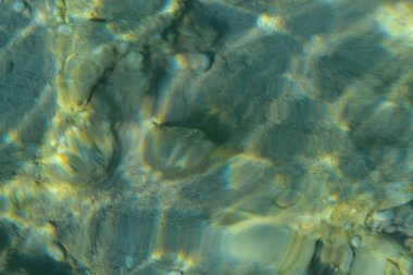 Turkuaz mavisi berrak su altında güzel renkli çakıl ve büyük taş, doğal deniz arka plan veya doku, üst görünümü