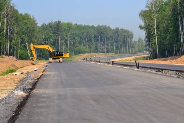 Paletli Ekskavatör kazma kova yüksek hızlı baypas yol inşaatı. İnşaat sanayi inşaatlarında kazı işleri için ağır makine ekipmanları. Rusya