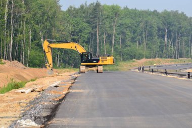 Paletli Ekskavatör kazma kova yüksek hızlı baypas yol inşaatı. İnşaat sanayi inşaatlarında kazı işleri için ağır makine ekipmanları. Rusya