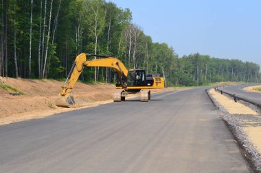 Paletli Ekskavatör kazma kova yüksek hızlı baypas yol inşaatı. İnşaat sanayi inşaatlarında kazı işleri için ağır makine ekipmanları. Rusya