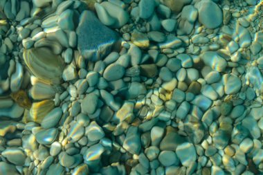 Bulanık doğal arka plan. Berrak deniz suyundan çakıl taşları.