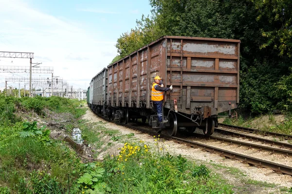 16 de agosto de 2019 Rusia, Podolsk. - El tren de mercancías ferroviario hace una maniobra. El trabajador supervisa el movimiento — Foto de Stock