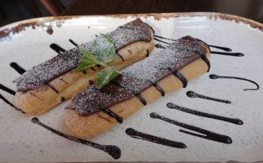 Çikolata yalıtılmış bir tabakta iki lezzetli eclairs